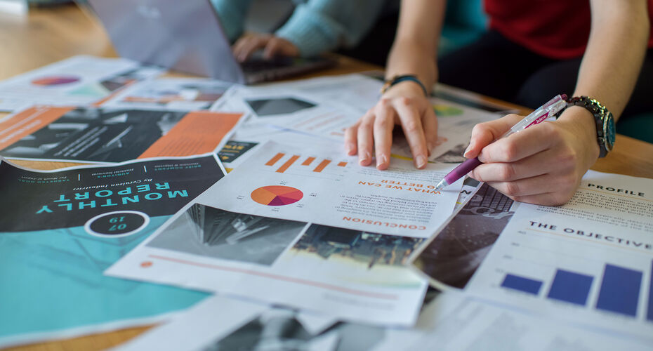 Printed pages showing graphs and graphics spread on a table