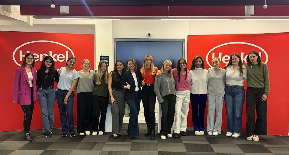 Group of female students in front of Henkel banners