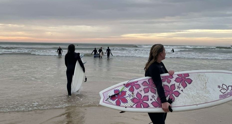 Surfers on a beach in the sunset