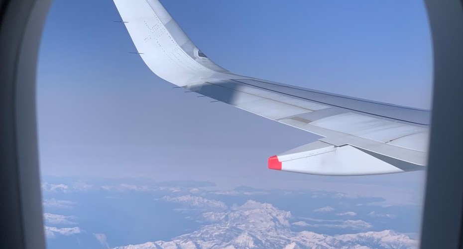View of snow covered mountains from the window of an aeroplane