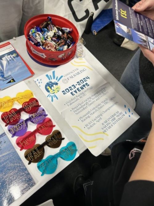 Sweets, brightly coloured sunglasses and a flyer advertising Fal Sail events on a table