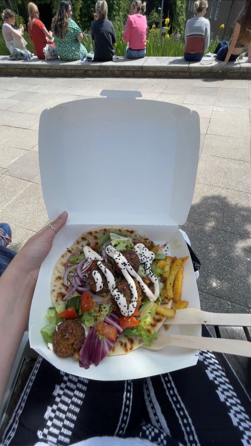 A box of brightly coloured takeaway food in the sun