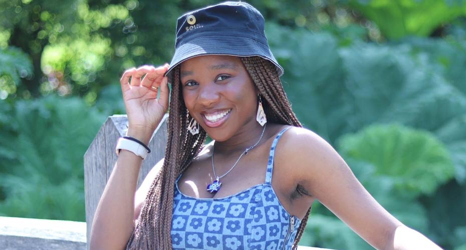 Nonye standing outside with greenery behind