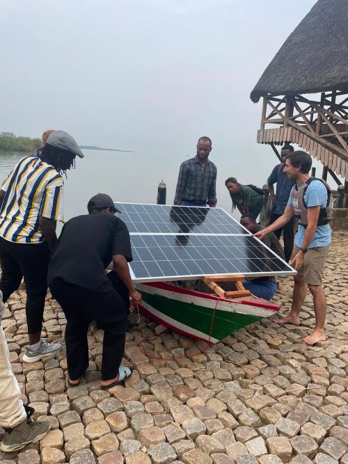 Josh and local students and fishermen adding solar panels to the boat