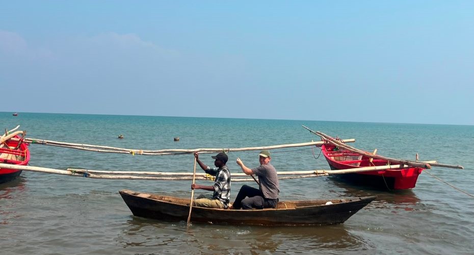 Josh and a local fisherman in a wooden rowing boat